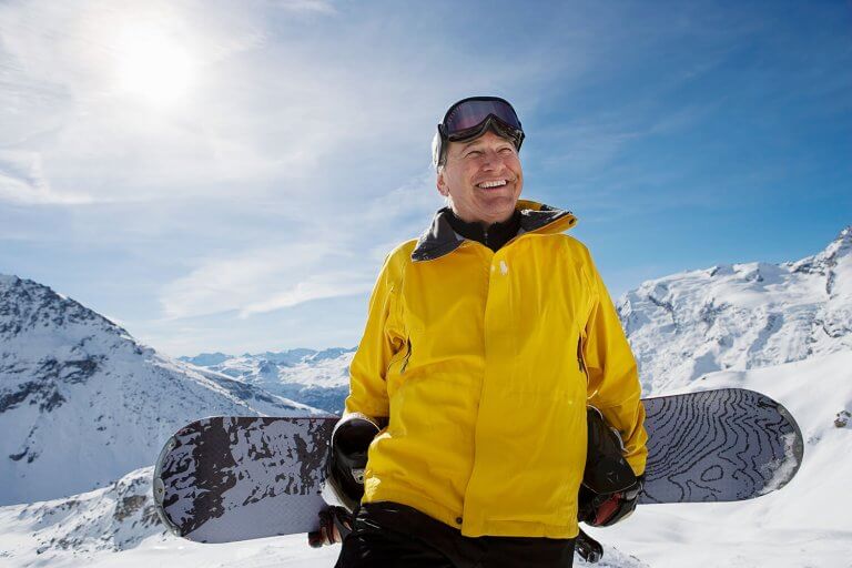 Mature male snowboarder with snowboard